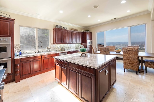 kitchen with stainless steel appliances, backsplash, crown molding, and a kitchen island