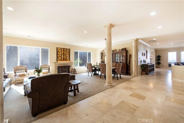 living room with light colored carpet, crown molding, and decorative columns