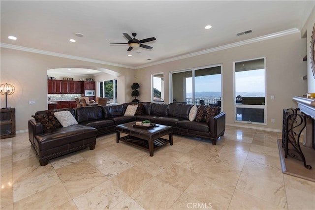 living room with crown molding, a wealth of natural light, and ceiling fan