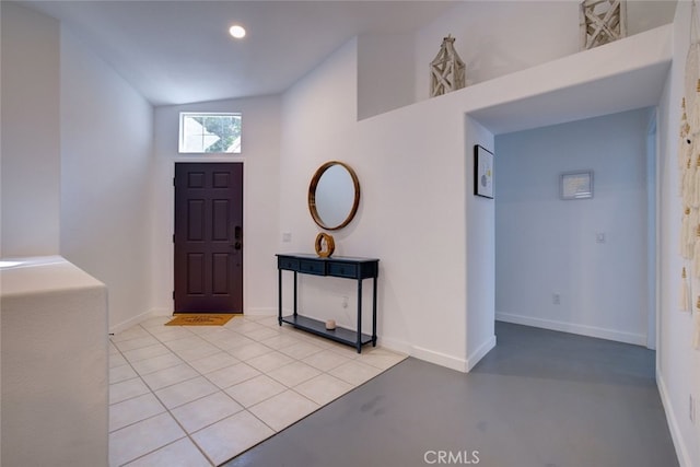 foyer featuring light tile patterned flooring and high vaulted ceiling