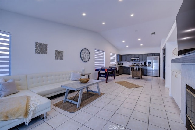 tiled living room with sink, plenty of natural light, and vaulted ceiling