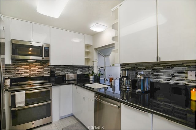 kitchen with white cabinets, appliances with stainless steel finishes, and sink