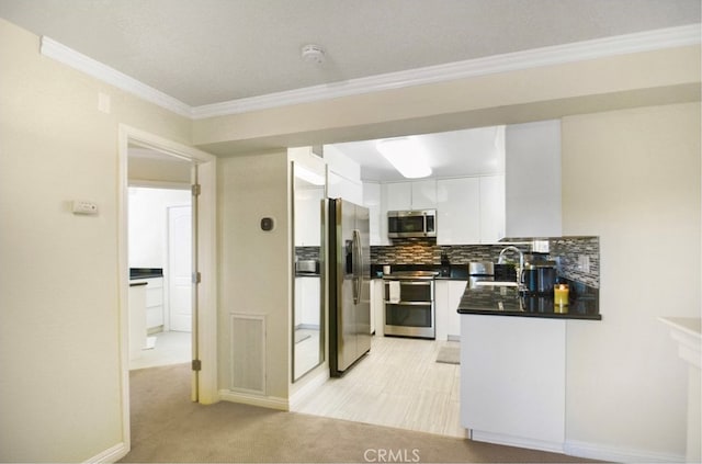 kitchen featuring sink, white cabinetry, light carpet, backsplash, and appliances with stainless steel finishes