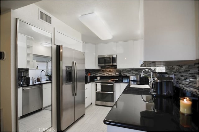 kitchen featuring backsplash, white cabinetry, sink, and stainless steel appliances