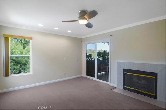 unfurnished living room featuring ornamental molding, a wealth of natural light, a high end fireplace, and carpet flooring