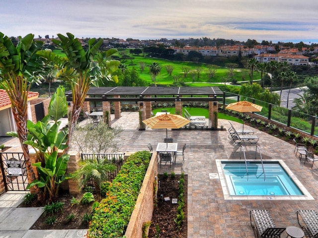 pool at dusk featuring a patio and a hot tub