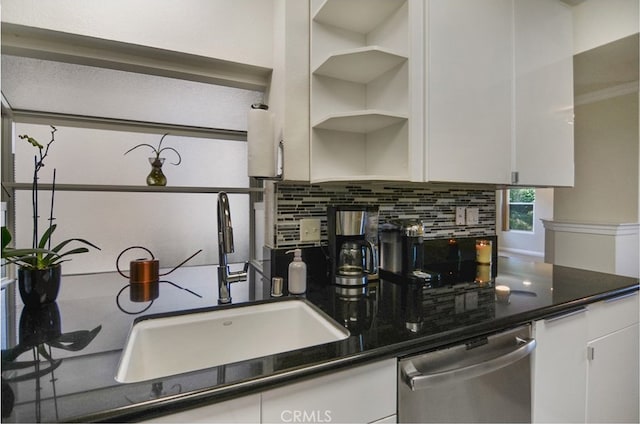 kitchen with white cabinets, backsplash, sink, and stainless steel dishwasher