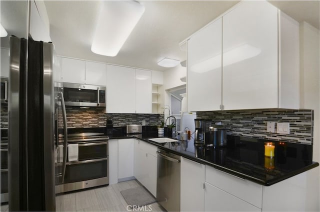 kitchen featuring appliances with stainless steel finishes, decorative backsplash, and white cabinets