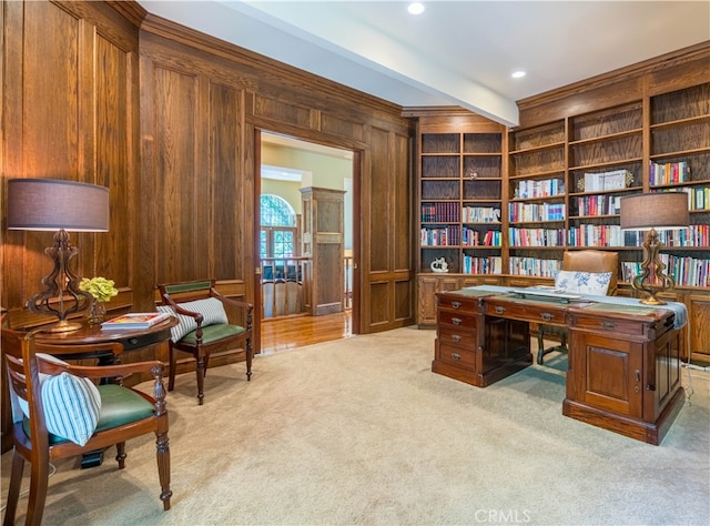 home office featuring beam ceiling, wood walls, and light colored carpet