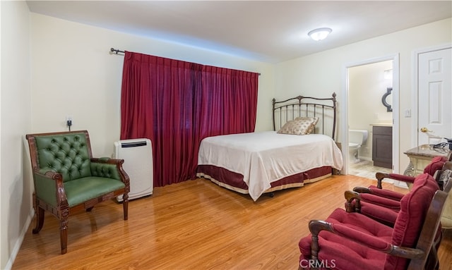 bedroom with wood-type flooring and ensuite bathroom