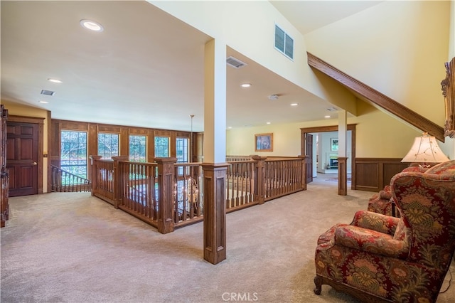 living room with wood walls and light colored carpet