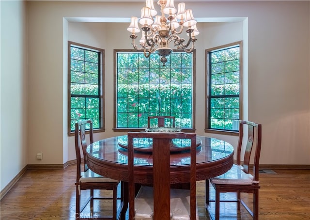 dining space featuring hardwood / wood-style floors, a chandelier, and plenty of natural light