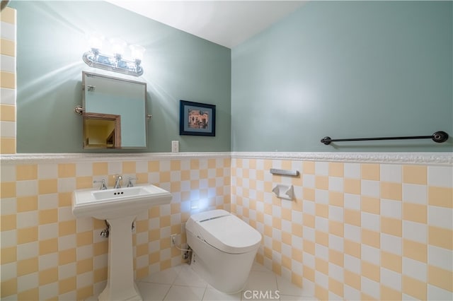 bathroom featuring tile walls, tile patterned floors, and toilet