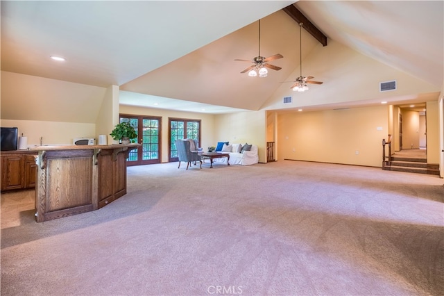 living room featuring ceiling fan, light colored carpet, and beamed ceiling