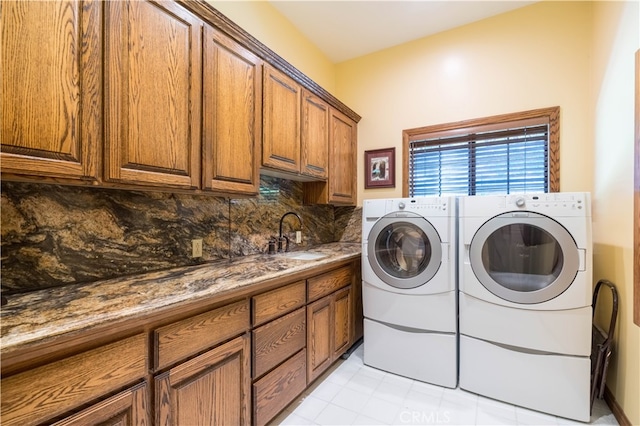 clothes washing area with cabinets, sink, washer and dryer, and light tile patterned flooring