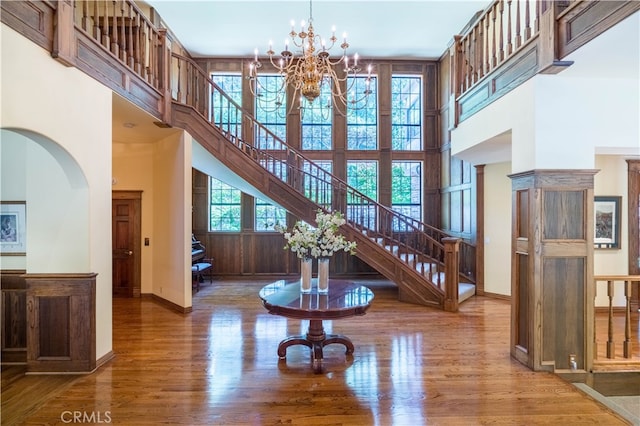 interior space featuring a towering ceiling, hardwood / wood-style floors, and a chandelier