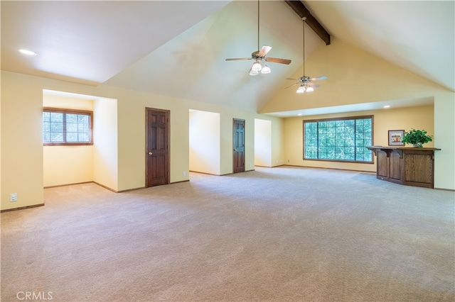 unfurnished living room featuring ceiling fan, beamed ceiling, high vaulted ceiling, and a wealth of natural light