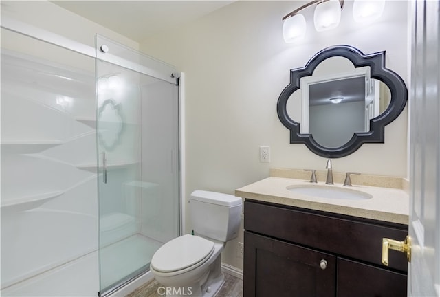 bathroom with vanity, toilet, and a shower with door