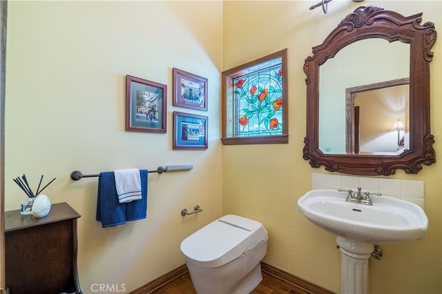 bathroom featuring wood-type flooring and toilet