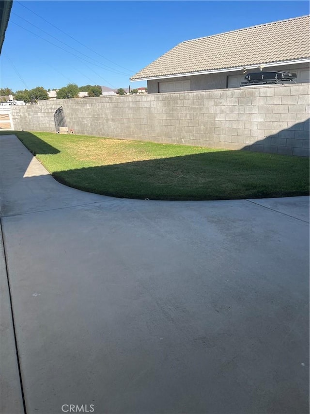 view of yard featuring fence and a patio