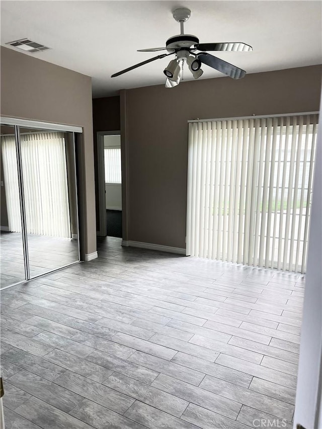 unfurnished room featuring a ceiling fan, visible vents, and wood finished floors