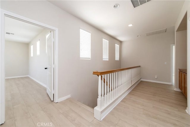 hall featuring plenty of natural light and light hardwood / wood-style flooring