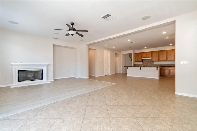 unfurnished living room featuring ceiling fan and light tile patterned floors