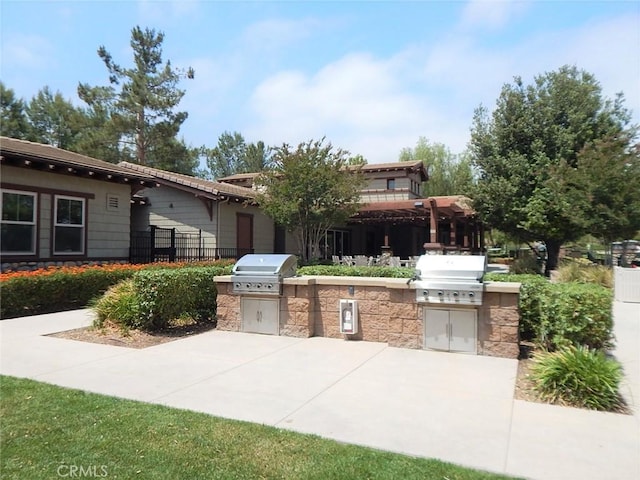 view of patio with an outdoor kitchen and a grill