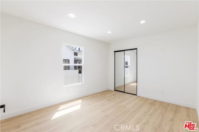 unfurnished room with light wood-type flooring