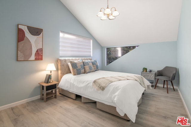 bedroom featuring an inviting chandelier, light wood-type flooring, and lofted ceiling