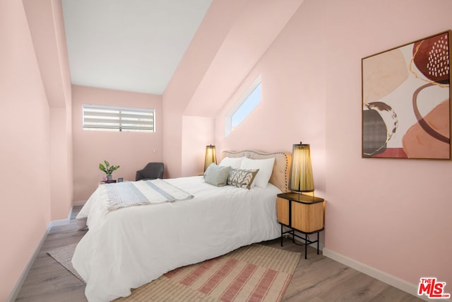 bedroom featuring lofted ceiling and light hardwood / wood-style floors