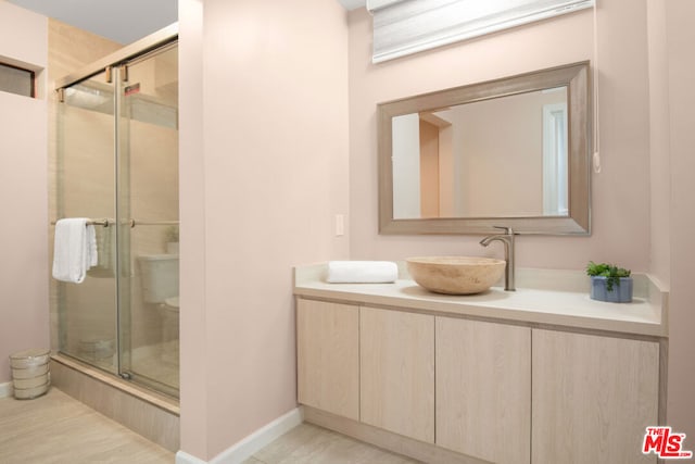 bathroom with vanity, a shower with shower door, and tile patterned floors