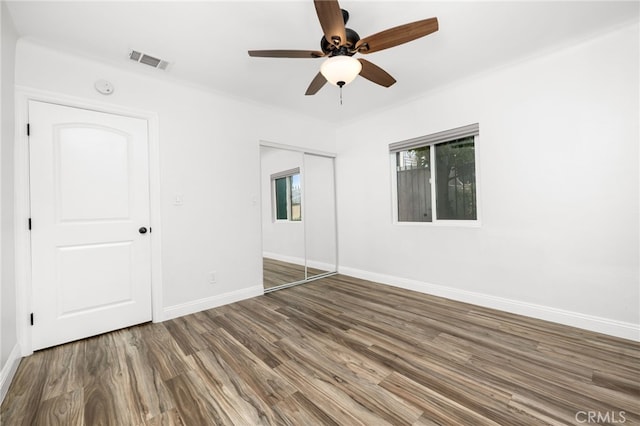 unfurnished bedroom featuring a closet, ceiling fan, and dark hardwood / wood-style flooring