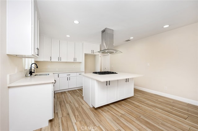 kitchen featuring white cabinetry, island range hood, a center island, and sink