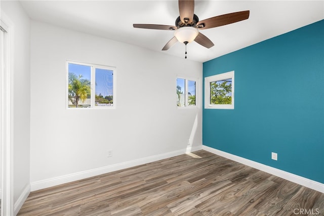 spare room featuring hardwood / wood-style flooring, ceiling fan, and a healthy amount of sunlight