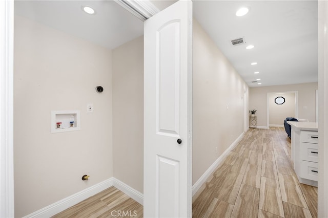 laundry area with washer hookup and light wood-type flooring