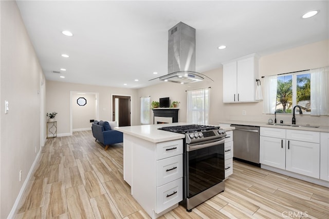 kitchen with white cabinetry, sink, stainless steel appliances, island exhaust hood, and light wood-type flooring