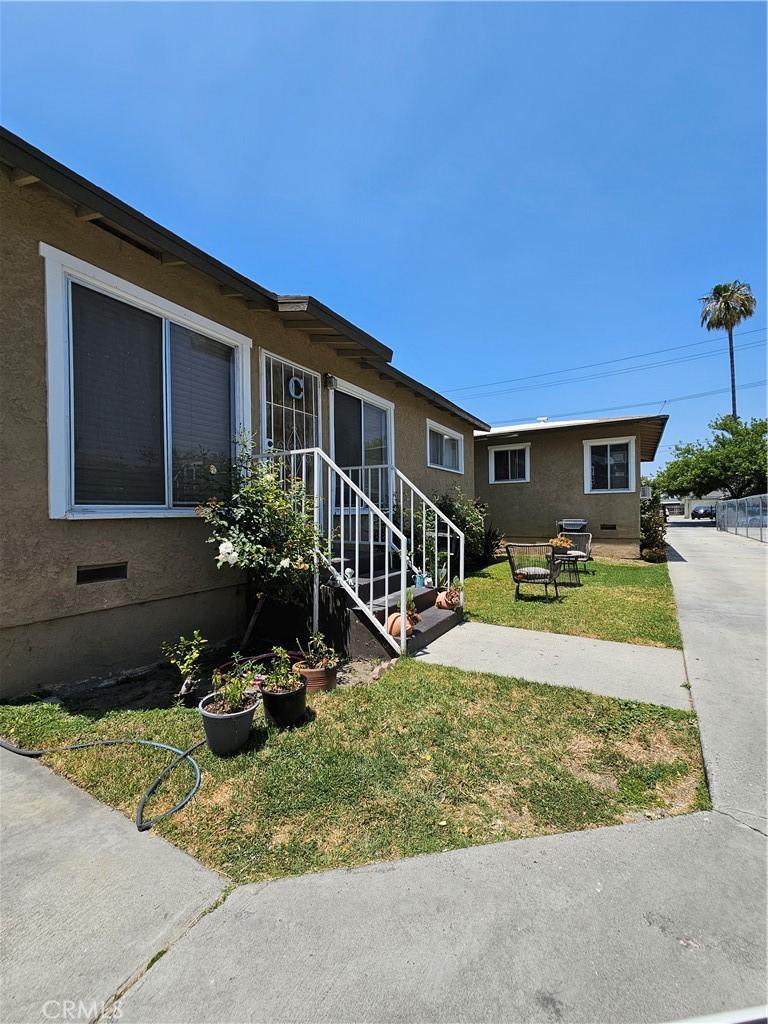 214 E Johnson St, Compton, CA 90220 - view of home's exterior with a lawn, crawl space, and stucco siding