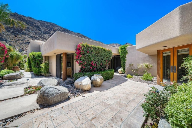 exterior space with a patio, french doors, and a mountain view