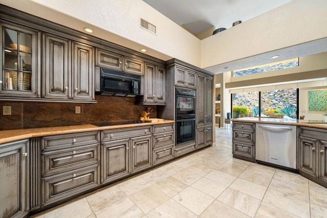 kitchen featuring sink, black appliances, decorative backsplash, and dark brown cabinetry