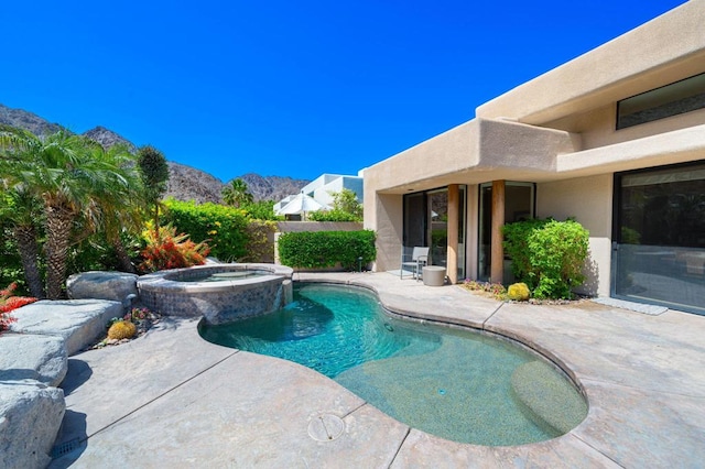 view of pool with a mountain view, a patio area, and an in ground hot tub