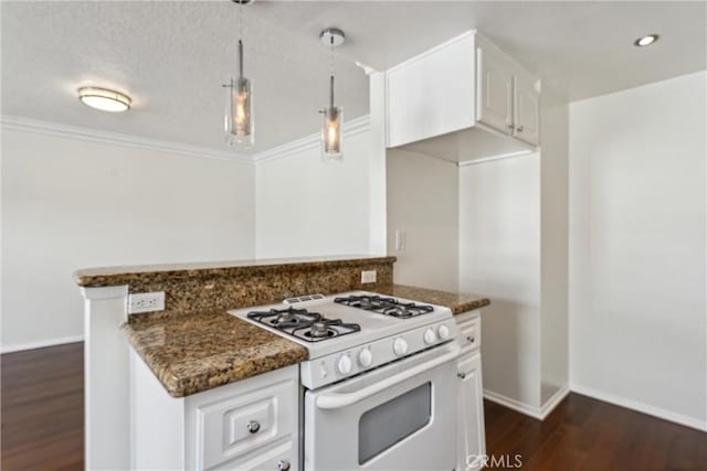 kitchen featuring dark wood-type flooring, hanging light fixtures, dark stone counters, white range with gas cooktop, and white cabinets