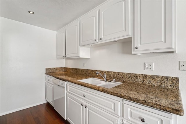 kitchen with dark stone countertops, white cabinetry, sink, and dishwasher