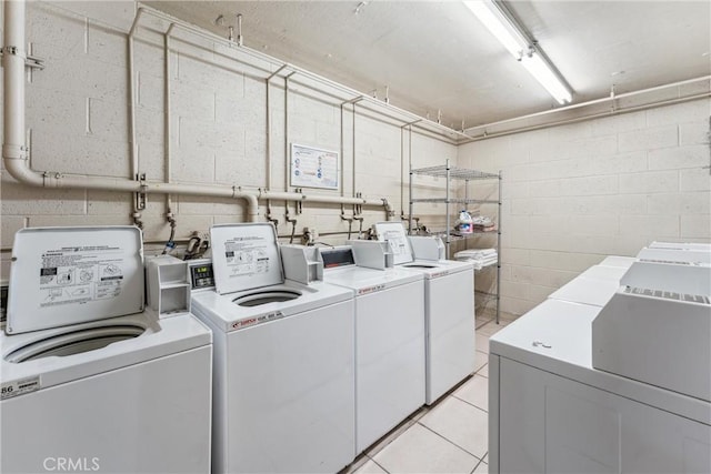 laundry room with washing machine and clothes dryer and light tile patterned floors