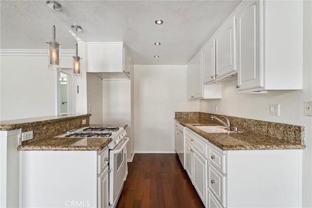 kitchen featuring white cabinets, dark stone countertops, white appliances, and sink