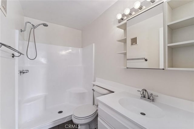 bathroom featuring toilet, a shower, and vanity