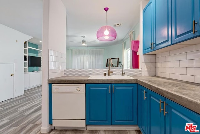 kitchen with blue cabinets, tasteful backsplash, white dishwasher, light wood-type flooring, and sink