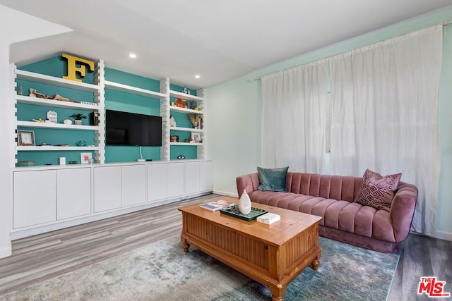 living room featuring hardwood / wood-style floors and built in features