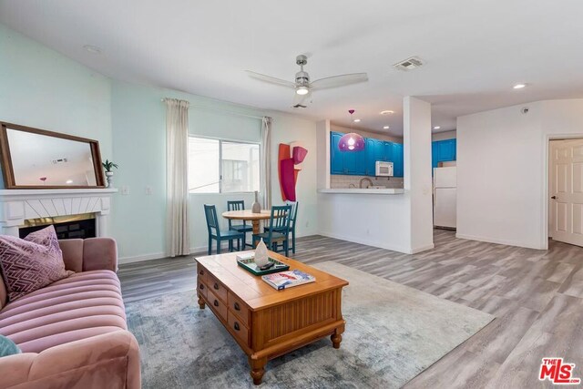 living room featuring ceiling fan and light wood-type flooring