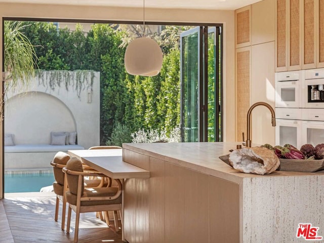 interior space featuring hanging light fixtures, white oven, and wood counters